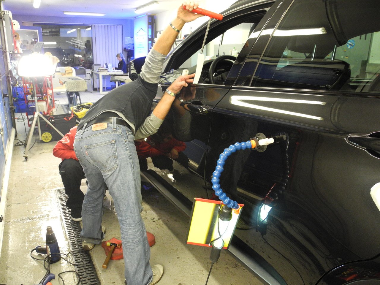 Dellenentfernung ohne Lackieren an einem schwarzen Fahrzeug